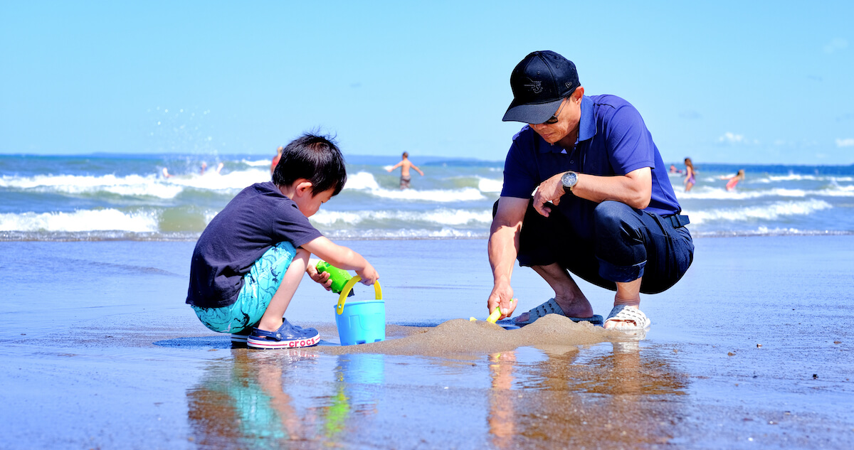 A man and his son playing with sand on Wasaga Beach